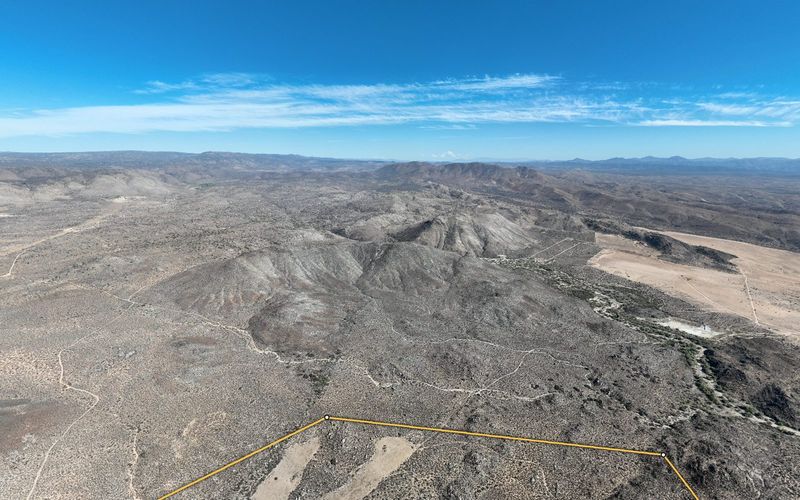 Vista desde el terreno en Ojos Negros hacia la sierra, con el lindero dorado en primer plano